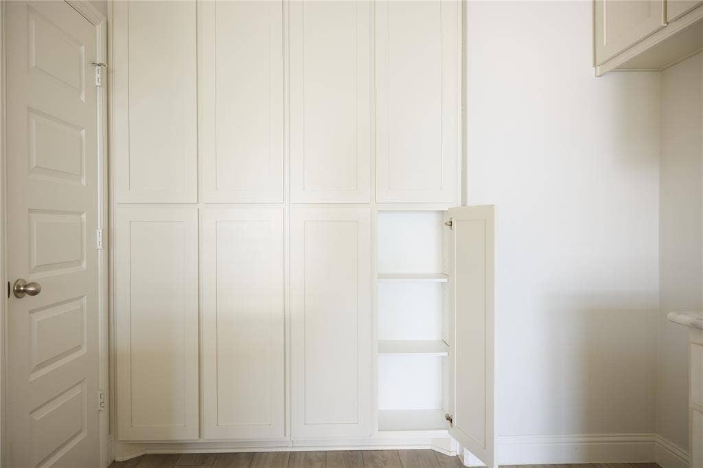 Floor-to-ceiling built-in cabinetry featuring Shaker-style doors, integrated shelving, and neutral-finish hardware