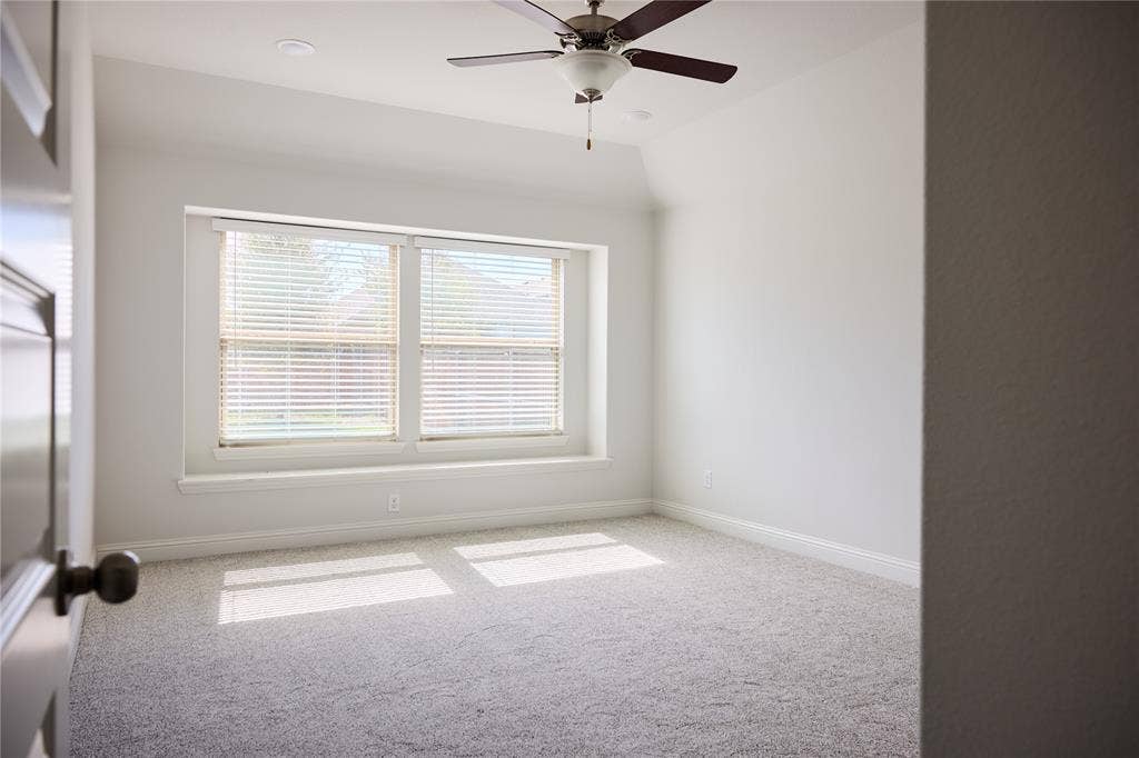 Neutral interior featuring a tray ceiling, wall-to-wall carpeting, recessed lighting, and a ceiling fan with integrated lighting