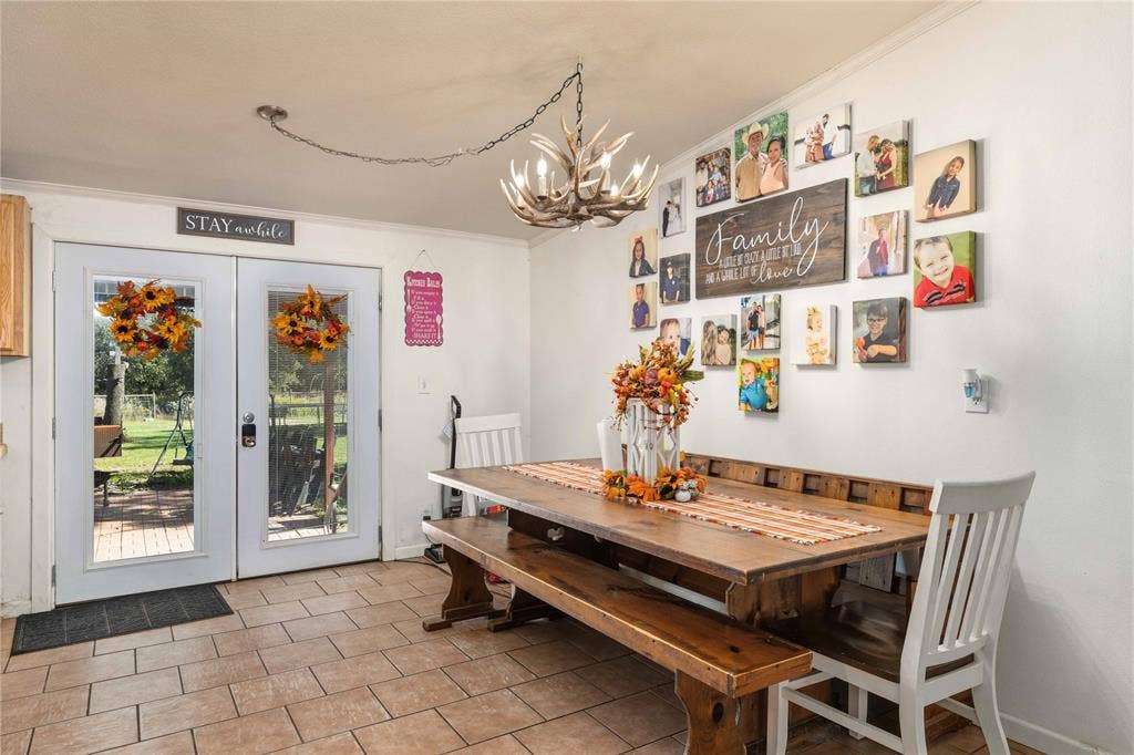 5540 County Road 334, Blanket, TX 76432 Double glass-paneled exterior doors featuring integrated blinds, ceramic tile flooring, and a decorative antler-style chandelier