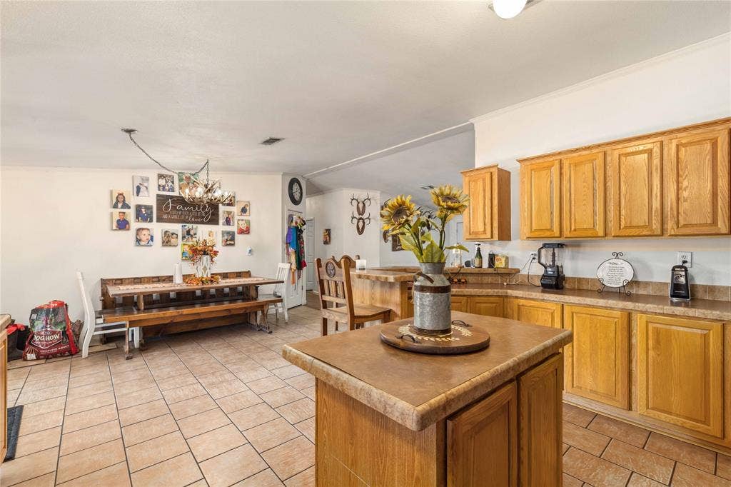 5540 County Road 334, Blanket, TX 76432 Kitchen featuring wood cabinetry, a center island with a stone-finish countertop, and tile flooring
