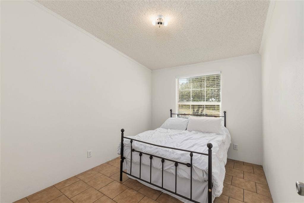5540 County Road 334, Blanket, TX 76432 Interior room featuring ceramic tile flooring, neutral walls, and a single-pane window with horizontal blinds