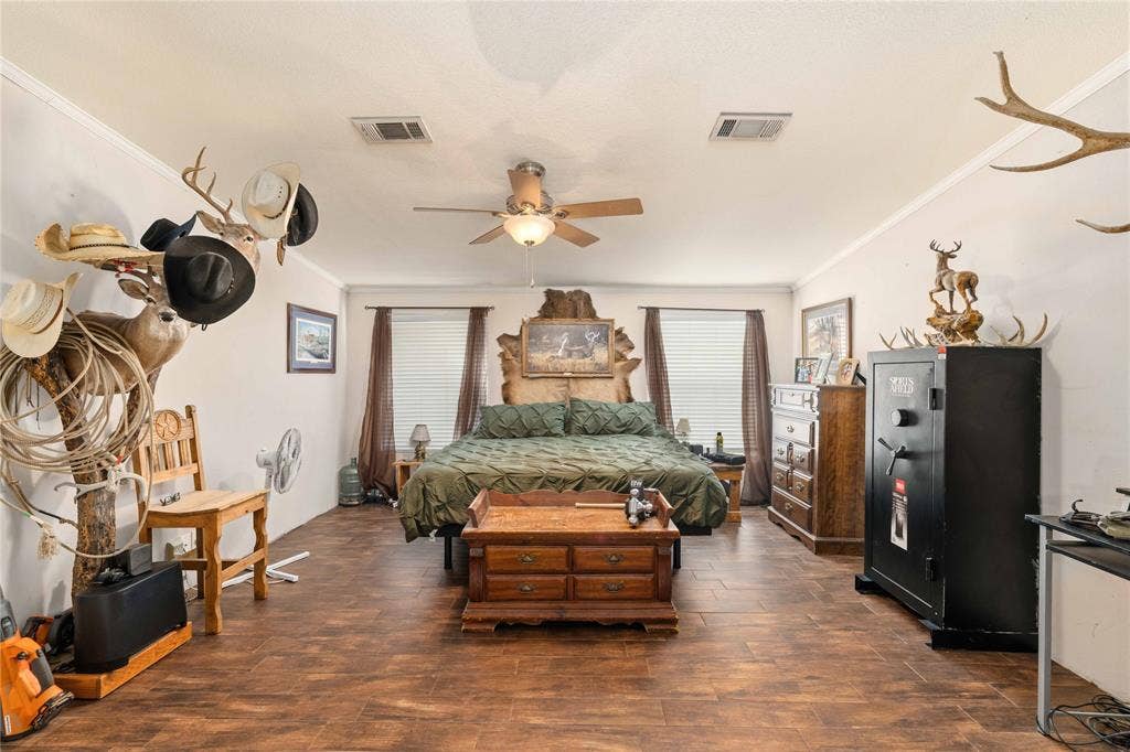 5540 County Road 334, Blanket, TX 76432 Wood-finish tile flooring, ceiling fan with integrated lighting, and dual windows with crown molding