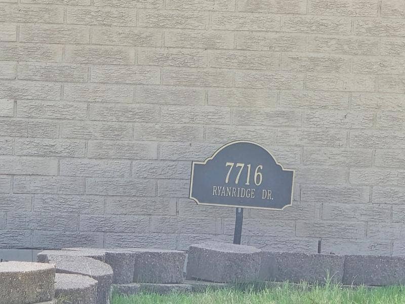 7716 Ryanridge Drive, Dallas, TX 75232 Exterior masonry brick wall featuring a decorative address plaque and stacked stone hardscaping