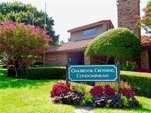 14800 Enterprise Drive, #22D, Farmers Branch, TX 75234 Exterior featuring clay tile roofing, brick facade, stone-textured chimney, and mature landscaping