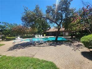 14800 Enterprise Drive, #22D, Farmers Branch, TX 75234 In-ground swimming pool featuring a concrete surround, mature shade trees, and integrated landscaping