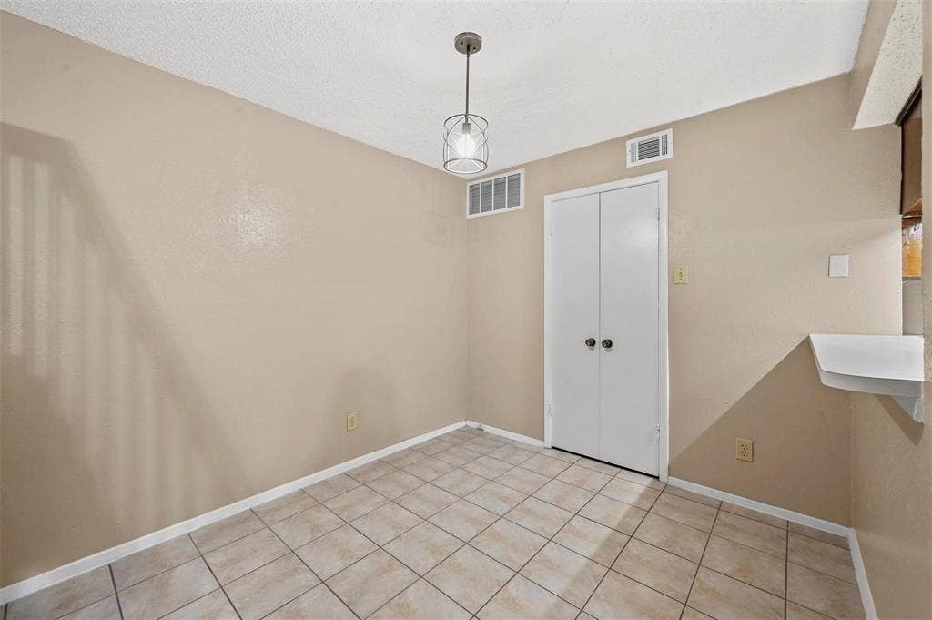 14800 Enterprise Drive, #22D, Farmers Branch, TX 75234 Ceramic tile flooring, neutral wall tones, double-door closet, and modern pendant lighting fixture