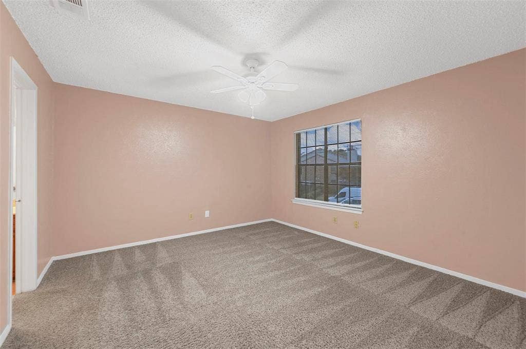 14800 Enterprise Drive, #22D, Farmers Branch, TX 75234 Room featuring neutral wall tones, carpeted flooring, a multi-pane window, and a ceiling fan with integrated light fixture