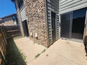 14800 Enterprise Drive, #22D, Farmers Branch, TX 75234 Concrete patio featuring brick exterior siding, horizontal wood-style siding, and sliding glass door entry