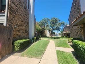 14800 Enterprise Drive, #22D, Farmers Branch, TX 75234 Brick exterior siding, concrete walkways, wood-finish privacy fencing, and manicured landscaping
