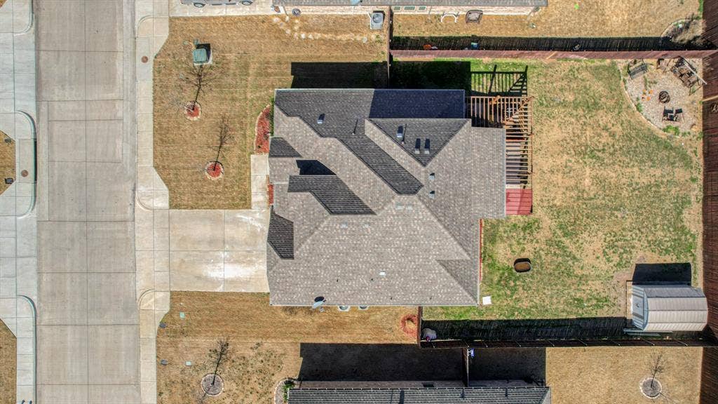 128 Breeders Drive, Willow Park, TX 76087 Aerial perspective featuring an asphalt shingle roof, a backyard wood pergola, a perimeter wood fence, and a detached storage structure
