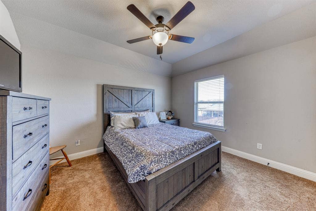 128 Breeders Drive, Willow Park, TX 76087 Tray ceiling featuring a central five-blade ceiling fan with integrated lighting and wall-to-wall carpeting