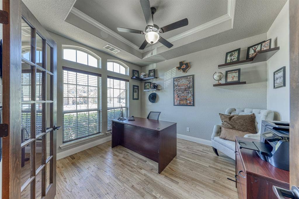 128 Breeders Drive, Willow Park, TX 76087 Room featuring a tray ceiling, wood-finish flooring, two large windows with arched transoms, and a French door entry