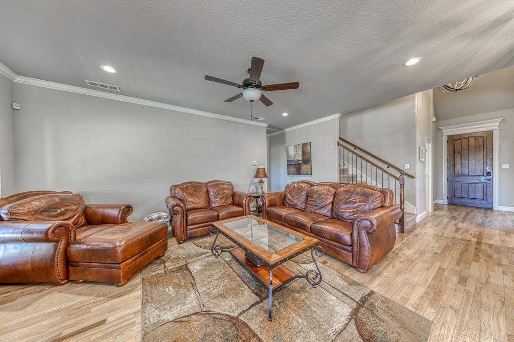 128 Breeders Drive, Willow Park, TX 76087 Wood-finish flooring, recessed lighting, ceiling fan with light fixture, staircase with metal balusters, and stained wood entry door
