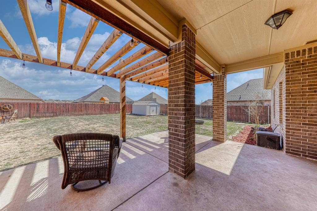 128 Breeders Drive, Willow Park, TX 76087 Covered concrete patio featuring a cedar pergola, brick structural pillars, and string lighting