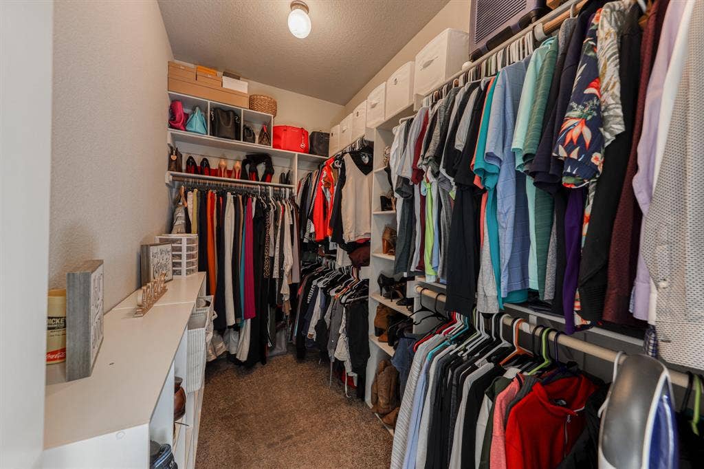 128 Breeders Drive, Willow Park, TX 76087 Walk-in closet featuring multi-level hanging rods, floor-to-ceiling built-in shelving, and carpeted flooring
