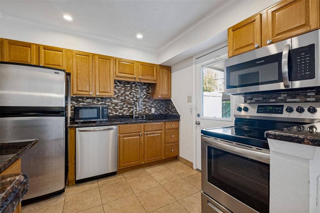 Enter the kitchen from the backdoor. Convenient from the parking spot under the carport. Granite counter tops.