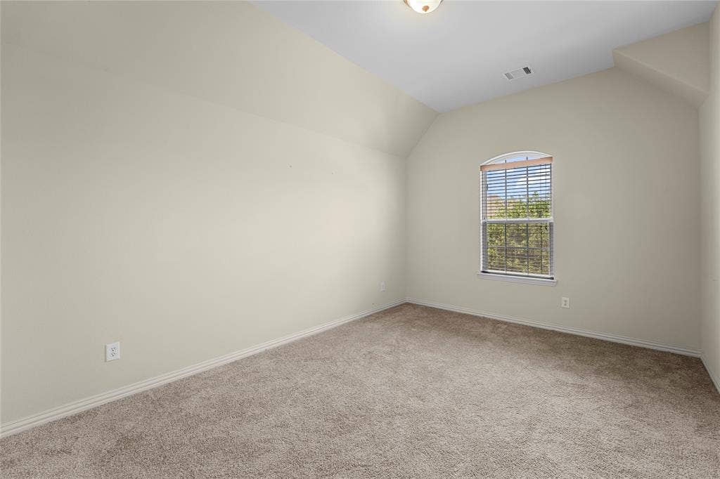 Interior space featuring high vaulted ceilings, wall-to-wall carpeting, and an arched window with horizontal blinds