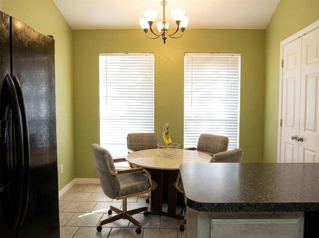 2306 Summit Drive, McKinney, TX 75071 Kitchen nook featuring ceramic tile flooring, dual windows with blinds, a multi-arm chandelier, and built-in closet storage