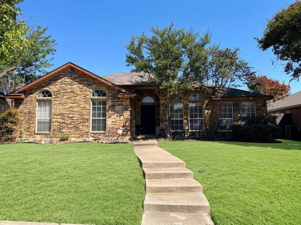 2306 Summit Drive, McKinney, TX 75071 Single-story brick exterior featuring a multi-gabled roofline, arched window detailing, and a concrete walkway