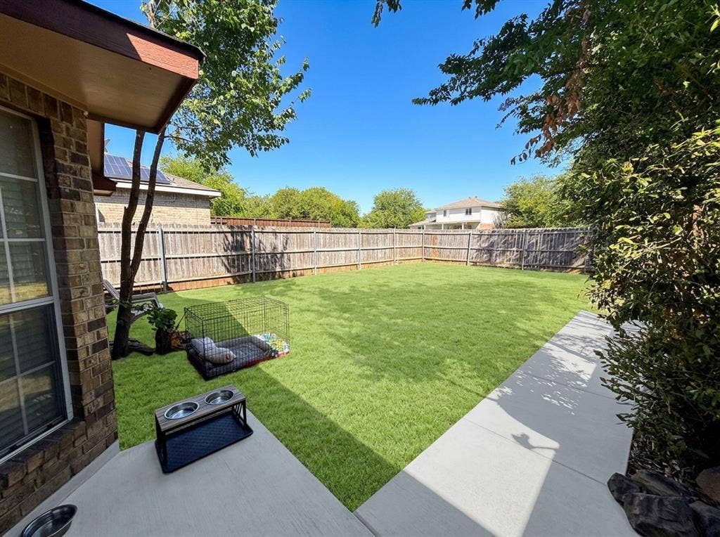 2306 Summit Drive, McKinney, TX 75071 Rear exterior featuring a concrete patio, sodded lawn, and perimeter wood privacy fencing
