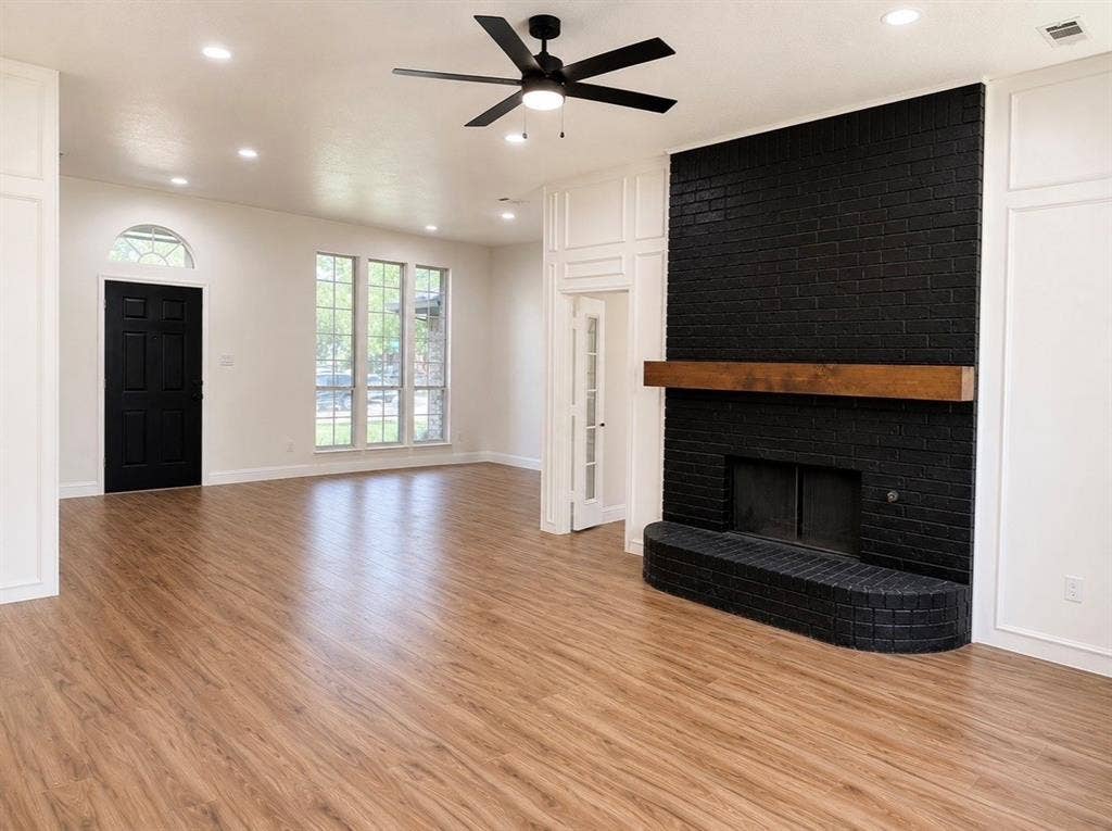 2400 Waterloo Lane, Mesquite, TX 75181 Floor-to-ceiling painted brick fireplace featuring a wood mantel, wood-finish flooring, recessed lighting, multi-pane windows, and a ceiling fan