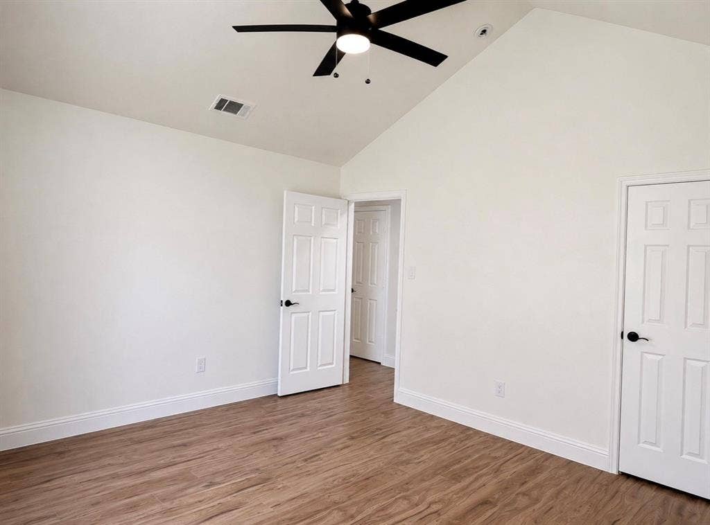 2400 Waterloo Lane, Mesquite, TX 75181 Vaulted ceilings featuring a matte black finish ceiling fan, wood-finish flooring, and six-panel interior doors with matte black hardware