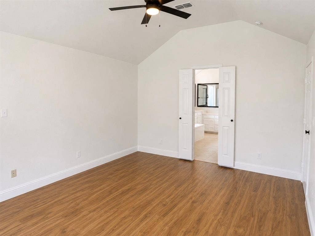 2400 Waterloo Lane, Mesquite, TX 75181 Vaulted ceiling featuring a central lighted ceiling fan, wood-finish flooring, and white paneled double doors
