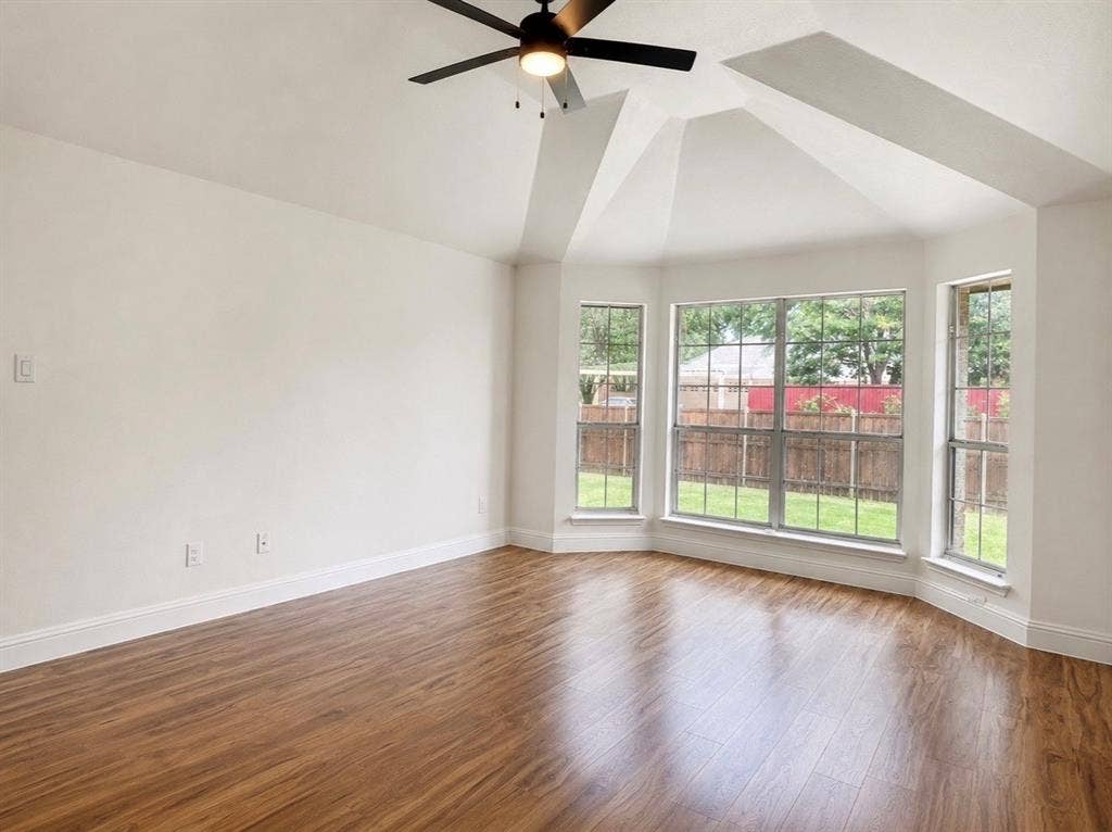 2400 Waterloo Lane, Mesquite, TX 75181 Vaulted ceilings, wood-finish flooring, bay windows, and a matte black ceiling fan with integrated lighting