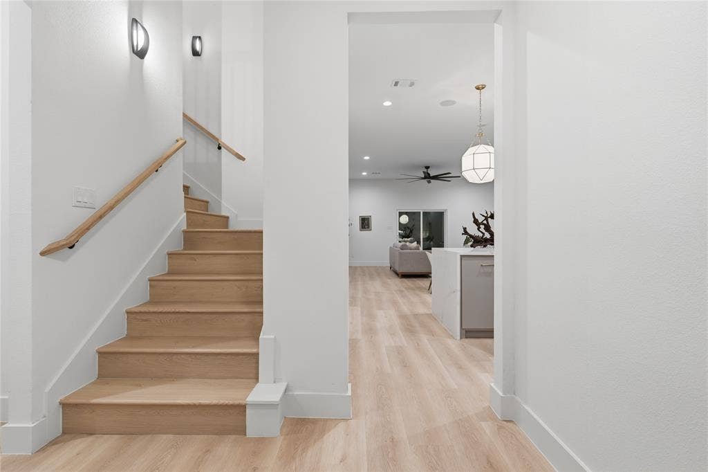 1834 Gallagher Street, Dallas, TX 75212 Staircase featuring wood-finish treads and a natural wood handrail, accompanied by wood-finish flooring, recessed lighting, and a geometric pendant fixture