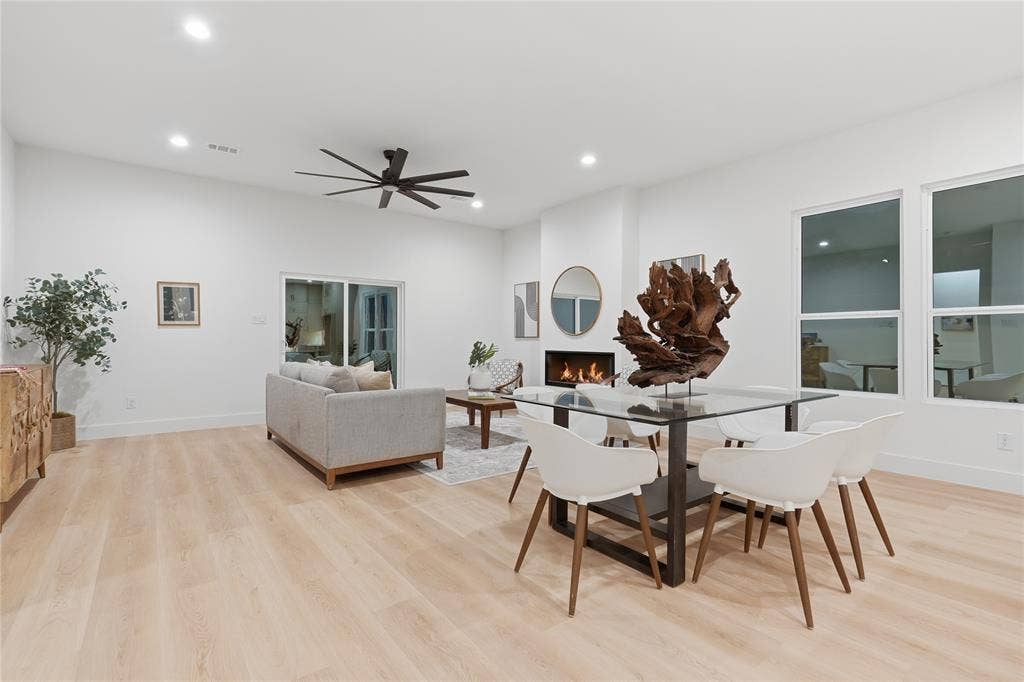 1834 Gallagher Street, Dallas, TX 75212 Open-concept area featuring high ceilings, wood-finish flooring, a wall-mounted fireplace, recessed lighting, and a multi-blade ceiling fan