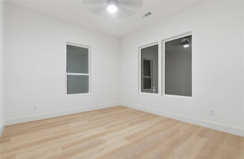 1834 Gallagher Street, Dallas, TX 75212 Interior space featuring wood-finish flooring, white walls, multiple windows, and a ceiling-mounted light fixture