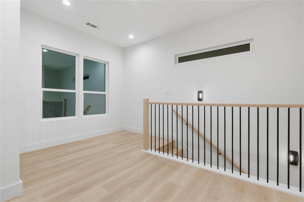 1834 Gallagher Street, Dallas, TX 75212 Interior space featuring wood-finish flooring, recessed lighting, a horizontal clerestory window, and a metal balustrade with a wooden handrail