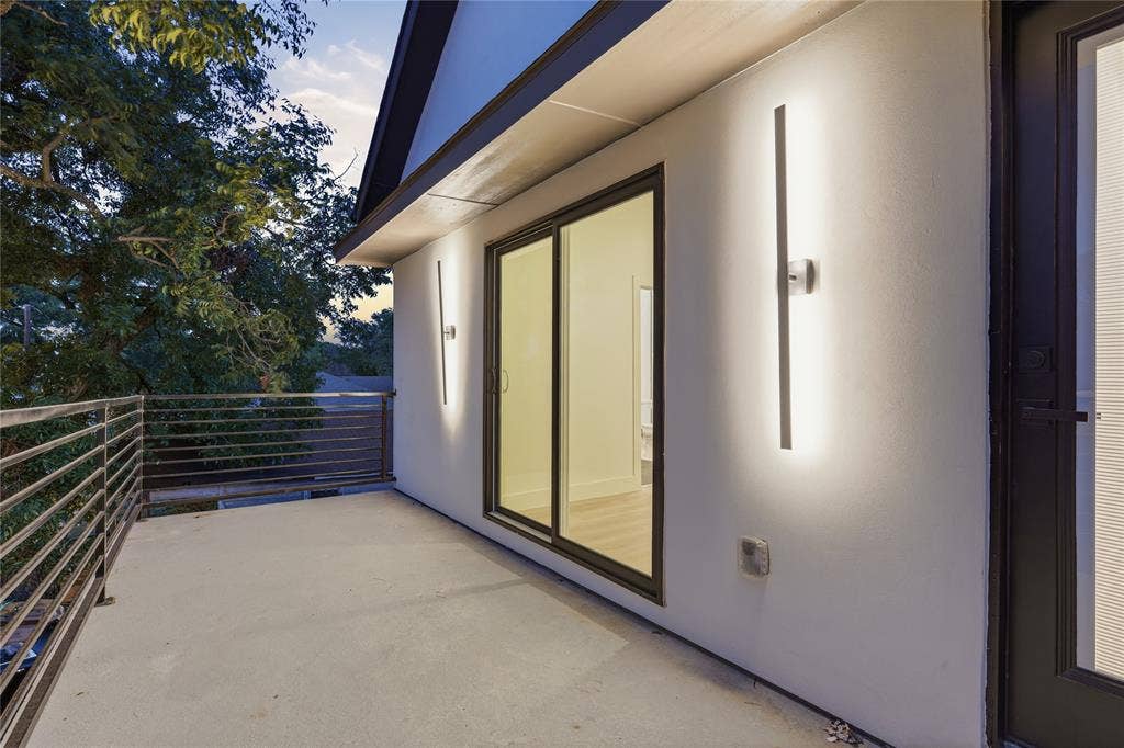 1834 Gallagher Street, Dallas, TX 75212 Covered balcony featuring horizontal metal railings, sliding glass door, and linear wall-mounted lighting