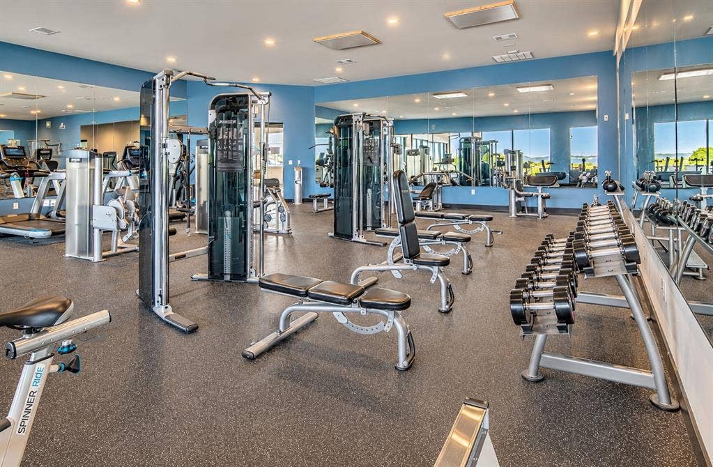 Fitness room featuring recessed lighting, wall-to-wall mirrors, and durable rubber flooring