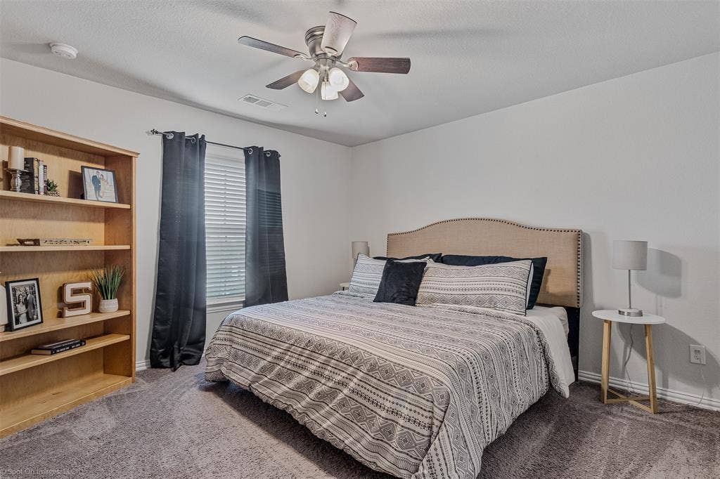1612 Village Creek Drive, Forney, TX 75126 Carpeted bedroom featuring ceiling fan and baseboards