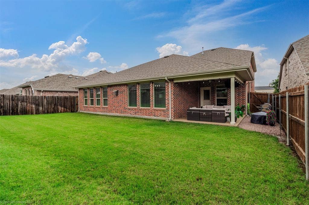 1612 Village Creek Drive, Forney, TX 75126 Rear view of property with an outdoor hangout area, a fenced backyard, brick siding, and a shingled roof