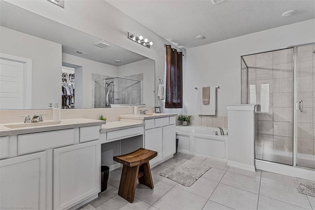 1612 Village Creek Drive, Forney, TX 75126 Full bathroom featuring double vanity, a shower stall, a garden tub, and tile patterned flooring