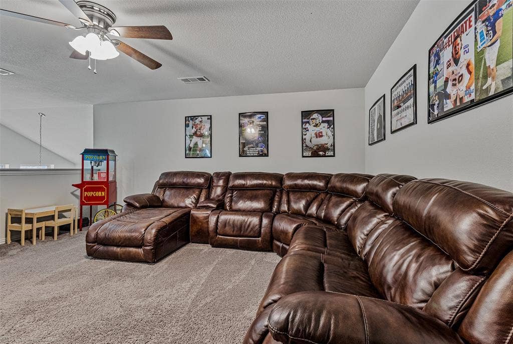 1612 Village Creek Drive, Forney, TX 75126 Carpeted living area featuring ceiling fan and a textured ceiling