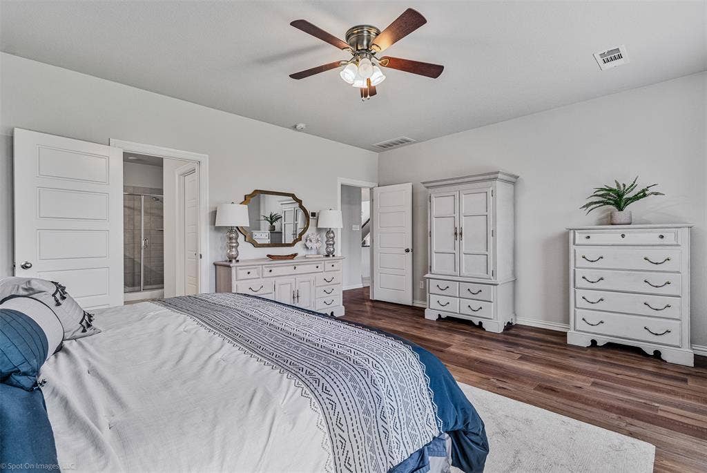 1612 Village Creek Drive, Forney, TX 75126 Bedroom featuring dark wood-type flooring, a ceiling fan, and ensuite bath