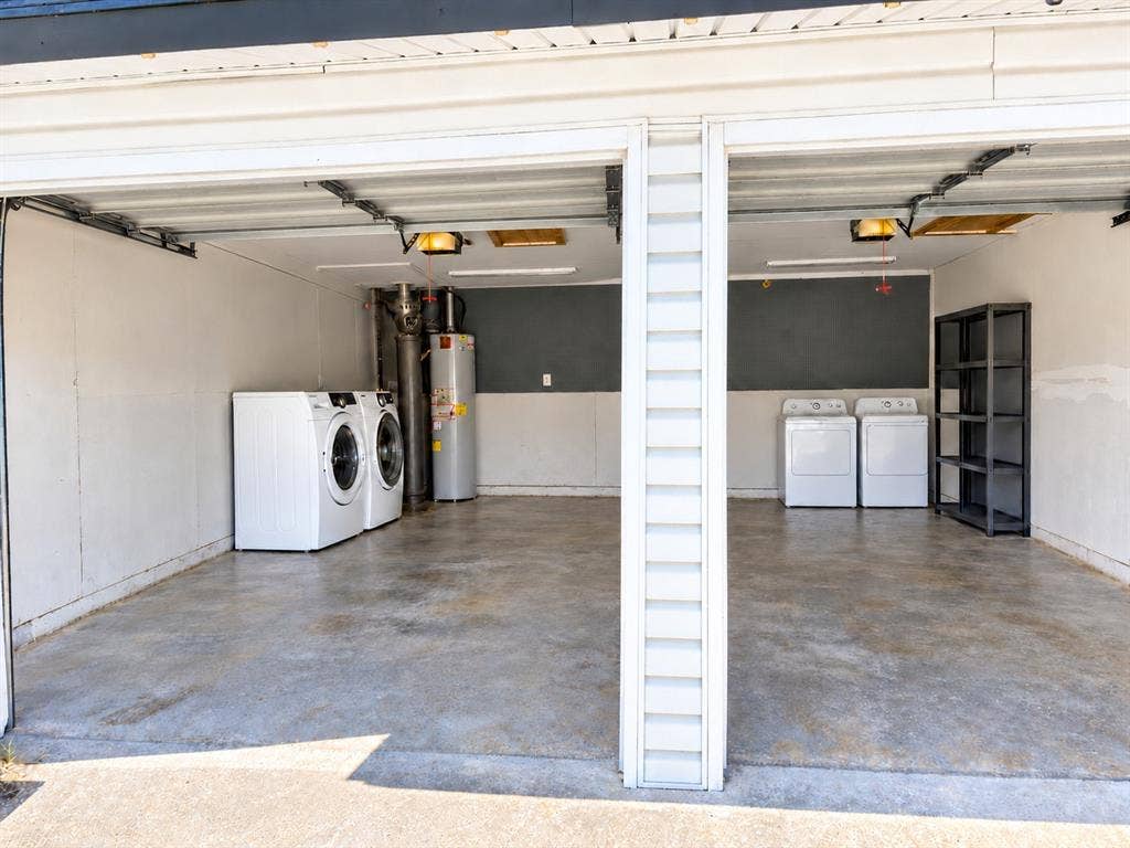 Two-car garage featuring a concrete floor, dual laundry hookups, and a water heater