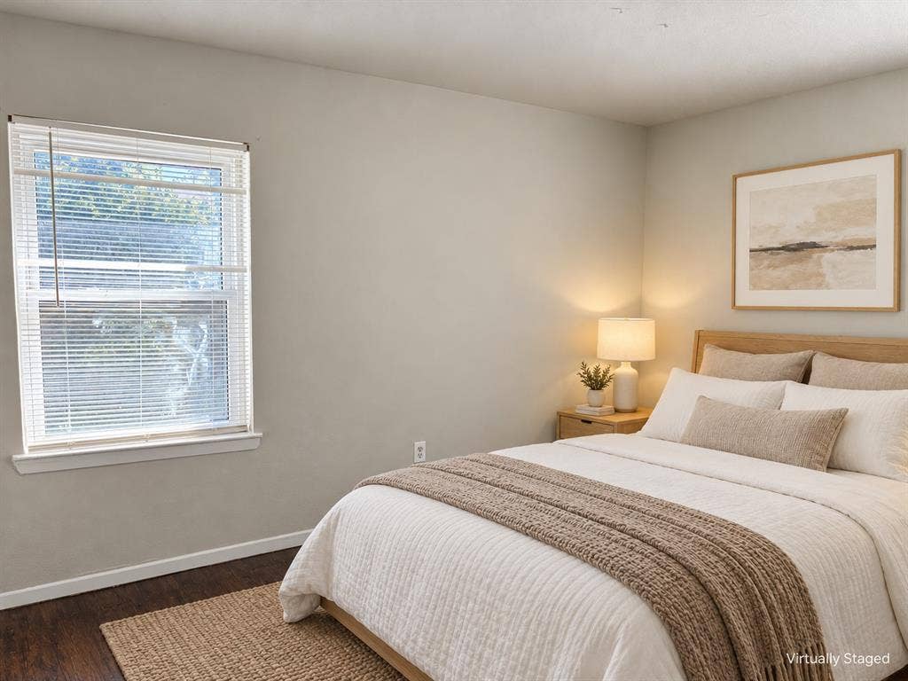 Neutral-toned walls, wood-finish flooring, and a window with horizontal blinds