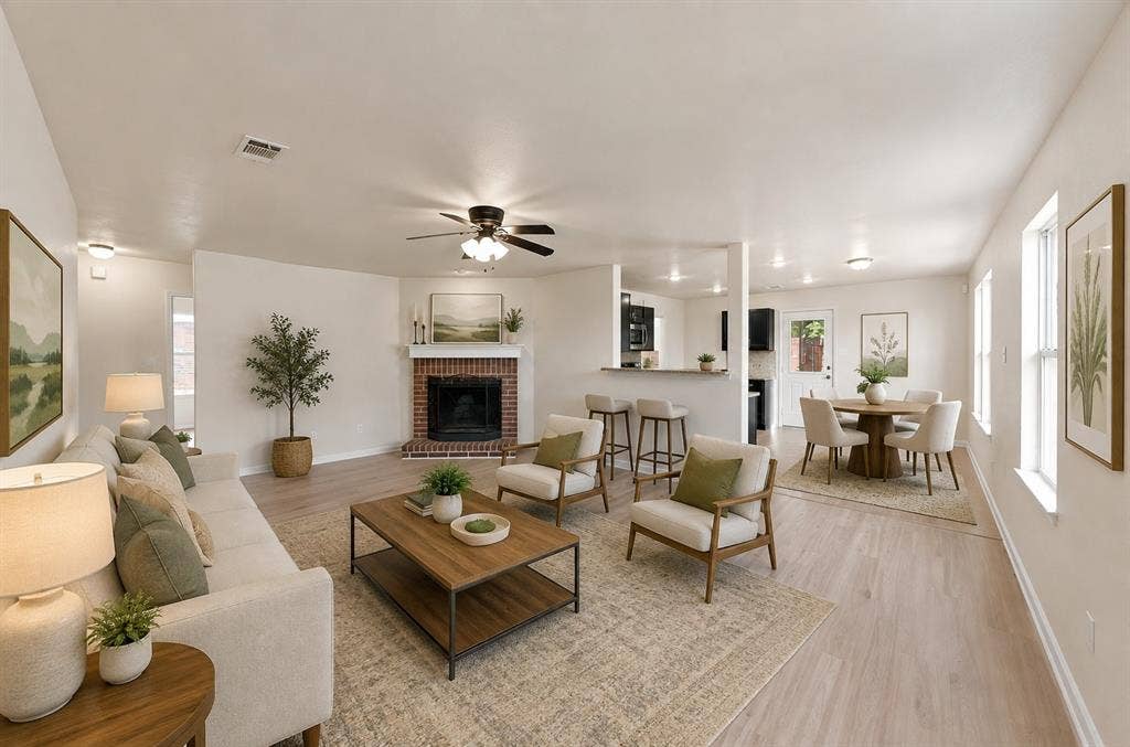 Open-concept living space featuring wood-finish flooring, a brick fireplace with a mantle, recessed lighting, and a kitchen pass-through counter