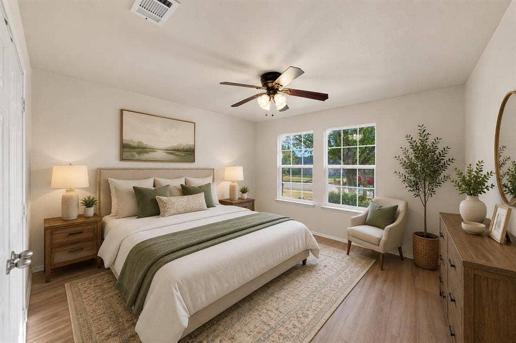 Wood-finish flooring, dual windows with grid detailing, and a ceiling fan with integrated lighting