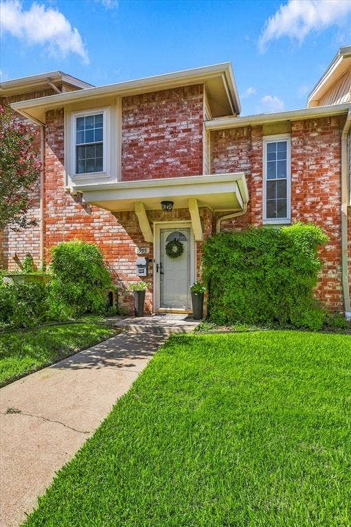 1955 Shorewood Drive, Grapevine, TX 76051 Brick exterior facade featuring a covered entryway, white-framed windows, and a concrete walkway