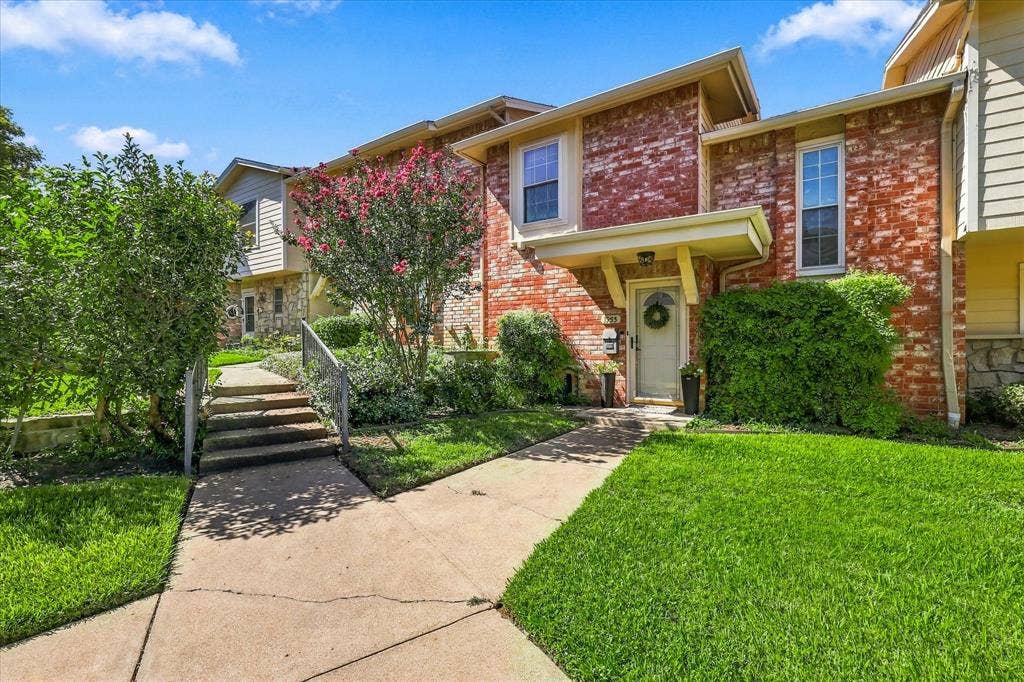 1955 Shorewood Drive, Grapevine, TX 76051 Multi-level exterior featuring red brick masonry, siding, concrete walkway, and landscaped grounds