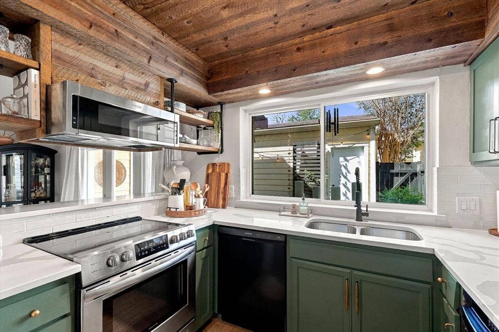 1955 Shorewood Drive, Grapevine, TX 76051 Kitchen featuring wood-paneled ceiling, white stone-finish countertops, subway tile backsplash, custom colored cabinetry, and stainless steel appliances