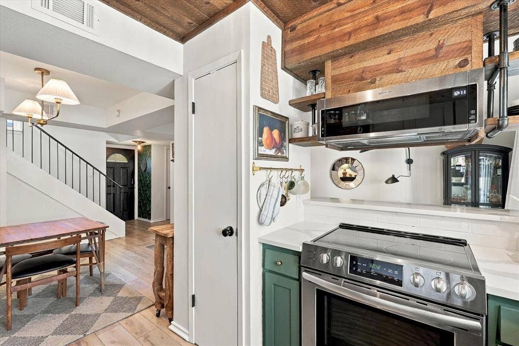 1955 Shorewood Drive, Grapevine, TX 76051 Kitchen featuring green cabinetry, stainless steel appliances, wood-paneled ceiling, and open shelving with industrial pipe detailing