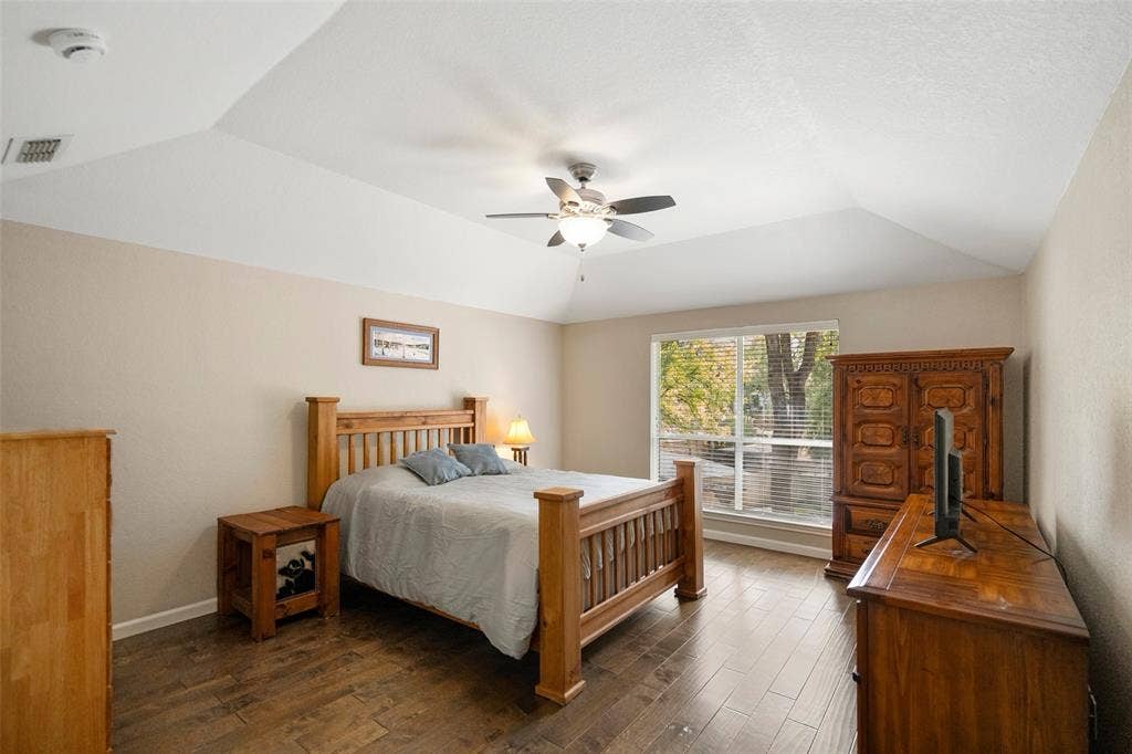 511 Casas Del Norte Court, Granbury, TX 76049 Primary bedroom with ceiling fan and wood-finish flooring and large windows overlooking the canal