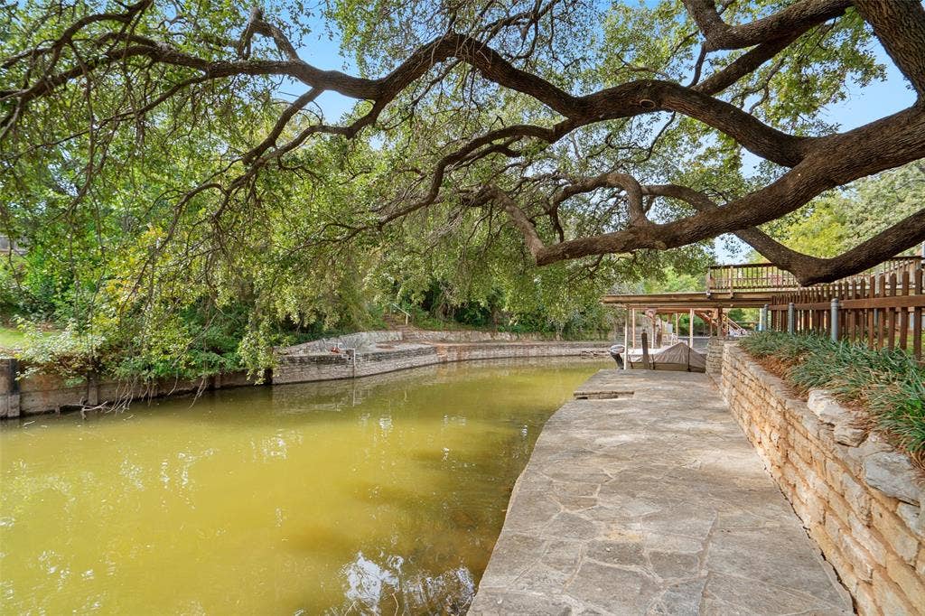 511 Casas Del Norte Court, Granbury, TX 76049 View of canal with stone wall and mature oak tree