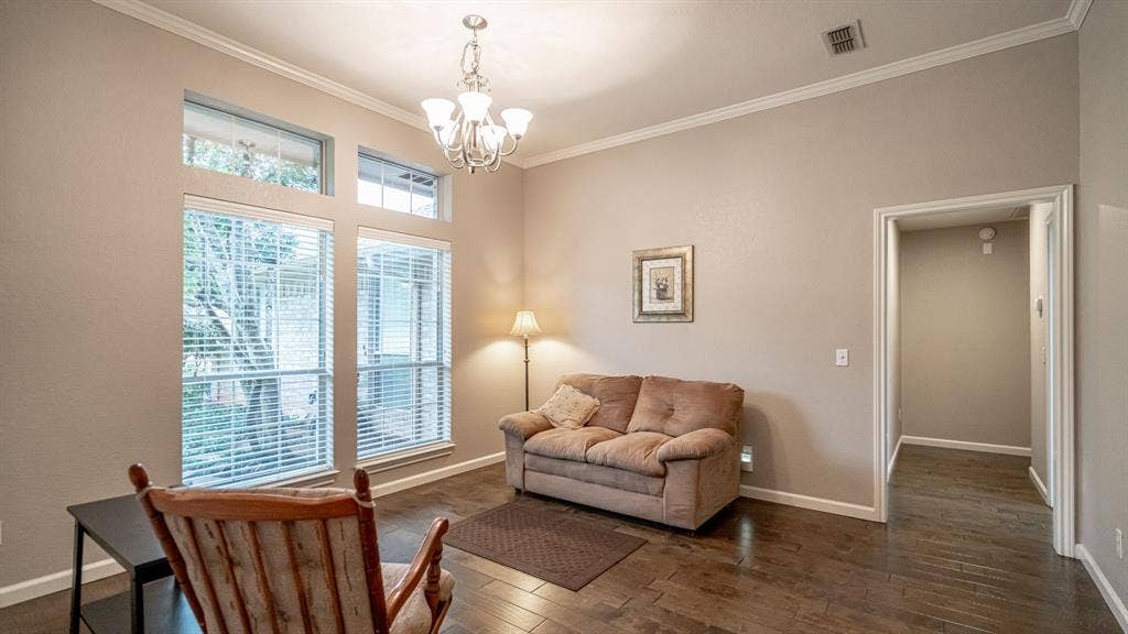 511 Casas Del Norte Court, Granbury, TX 76049 Dining room featuring wood-finish flooring, crown molding, multi-pane windows with transoms, and a classic chandelier